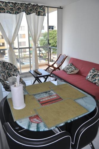 a living room with a glass table and a red couch at Apartamento in Santa Marta