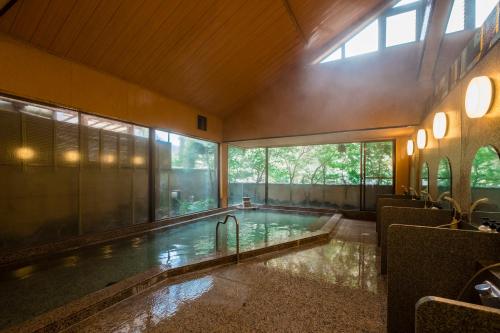 a swimming pool in a building with a large window at Yamagaso in Hakone