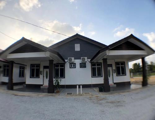 a house with two large roofs on a street at Twin Homestay B in Kuala Terengganu