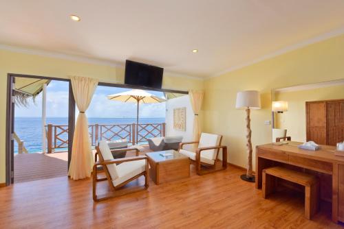 a living room with a view of the ocean at Dreamland Maldives Resort in Baa Atoll