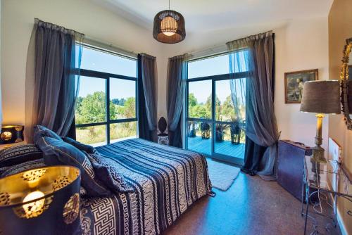 a bedroom with a bed and a large window at Copper Gate in Mapua