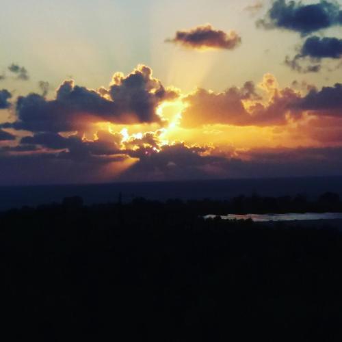 a sunset with clouds in the sky at Armiriki Apartments in Korakokhórion