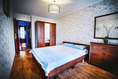 een slaapkamer met een bed, een ladekast en een spiegel bij 2-bedroom on Mykolaychuka street in Vinnytsya