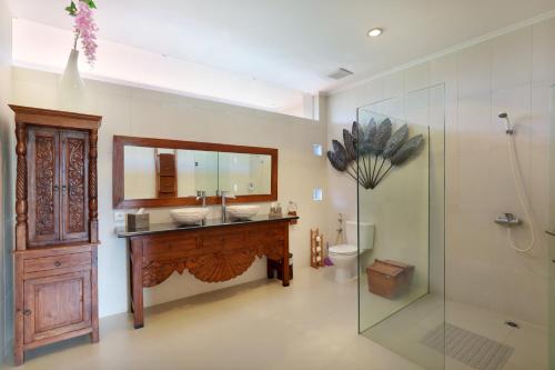 a bathroom with a sink and a mirror and a shower at Villa Mawar Legian in Legian