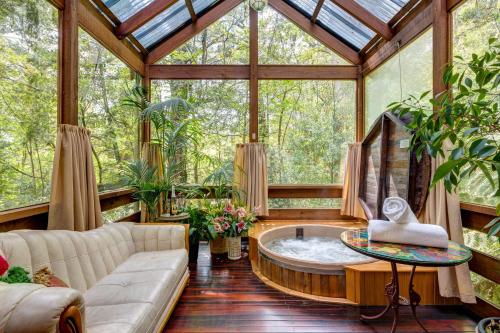 a living room with a jacuzzi tub in a conservatory at Arcadia Cottages in Olinda