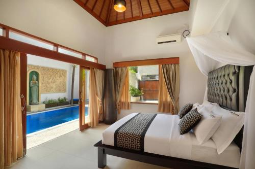 a bedroom with a bed and a swimming pool at Villa Mawar Legian in Legian