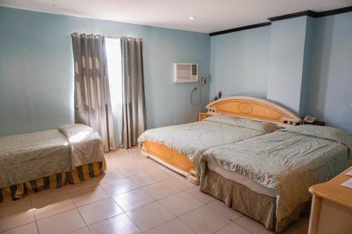 Un pat sau paturi într-o cameră la Crowne Garden Hotel