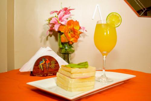 a plate of food and a glass of orange juice at Hotel Ventura Isabel in Iquitos