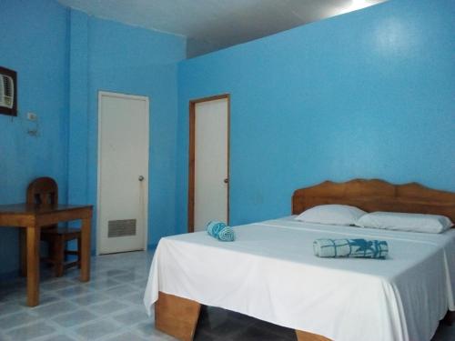 ein blaues Schlafzimmer mit einem Bett und einer blauen Wand in der Unterkunft John Lhea Beach Cottages in Siquijor