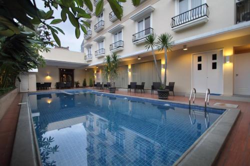 a hotel swimming pool in front of a building at Emersia Malioboro Hotel in Yogyakarta