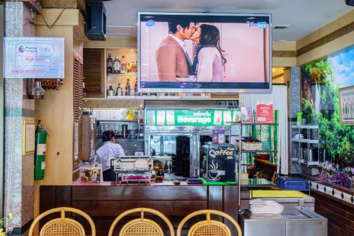 a large screen above a bar in a restaurant at โรงแรมศิริโฮเต็ล Sirihotel Korat in Nakhon Ratchasima
