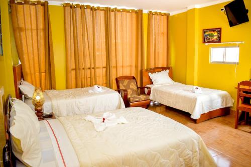 a hotel room with two beds with towels on them at Hotel Ventura Isabel in Iquitos