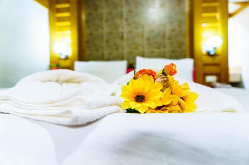 a bouquet of flowers sitting on top of a bed at โรงแรมศิริโฮเต็ล Sirihotel Korat in Nakhon Ratchasima
