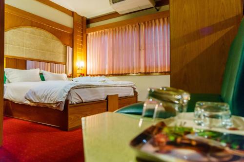a hotel room with a bed and a table at โรงแรมศิริโฮเต็ล Sirihotel Korat in Nakhon Ratchasima