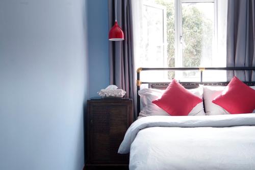 a bedroom with a bed with red and white pillows at Hangzhou JiuYueJi Bed&Breakfast in Hangzhou