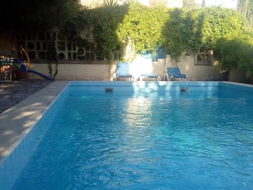 une piscine avec de l'eau bleue dans une cour dans l'établissement Le Paradis de Valérie, à Sète