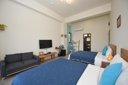 a hotel room with two beds and a couch at 有棵樹特色民宿The Tree in Hengchun