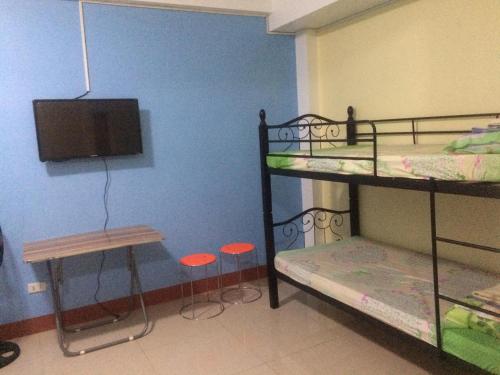 a room with two bunk beds and a tv at Mayon Lodging House in Legazpi