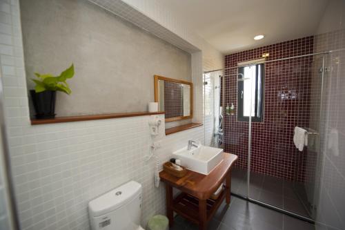 a bathroom with a toilet and a sink and a shower at 有棵樹特色民宿The Tree in Hengchun