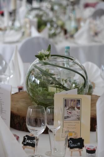 a table with two wine glasses and a vase at Hotel Derichsweiler Hof in Nümbrecht