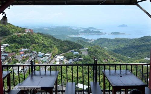 a balcony with two benches and a view of the ocean at Jiou Fen Seaside HomeStay in Jiufen