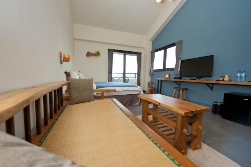 a bedroom with a bed and a couch and a television at 有棵樹特色民宿The Tree in Hengchun