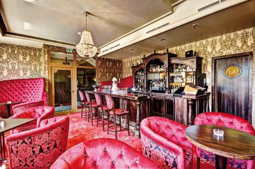 a bar in a restaurant with red chairs and tables at Hotel Suitess in Dresden