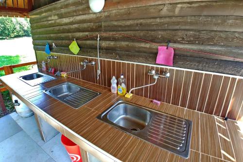 a kitchen with two sinks and a wooden counter at Camping & Glamping Jezersko ex Cvet Gora in Zgornje Jezersko