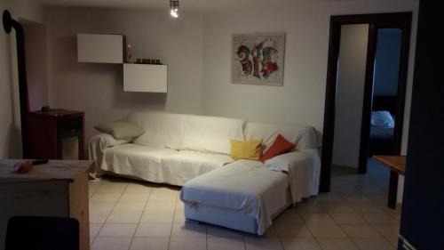 uma sala de estar com um sofá branco e um banco em Casa Elisa em Doues