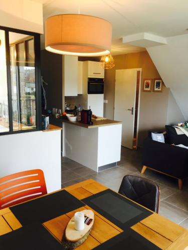 un salon avec une table et une cuisine dans l'établissement Charmant Appartement Saint Malo Saint Servan, à Saint-Malo