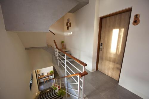 a staircase in a house with a wooden door at 有棵樹特色民宿The Tree in Hengchun