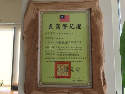 a sign in a wooden frame hanging on a wall at 有棵樹特色民宿The Tree in Hengchun