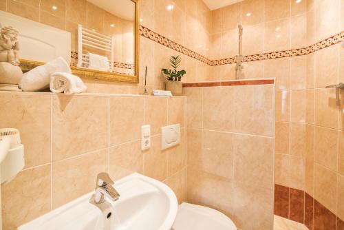 a bathroom with a sink and a toilet and a shower at Zur Schönen Aussicht Hotel garni in Garmisch-Partenkirchen