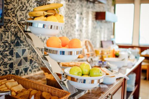 فندق نيو تيفليس في تبليسي: بوفيه يحتوي على بيض وفاكهة في أطباق وخبز