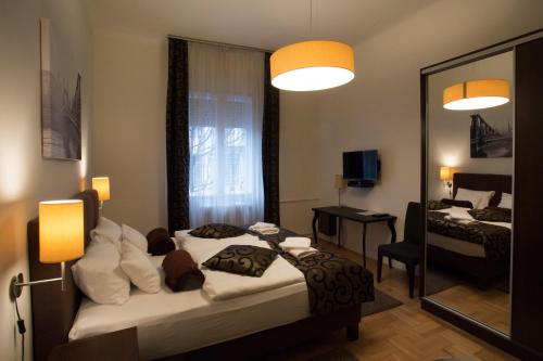 ブダペストにあるOpus Prime Apartmentのベッドと鏡が備わるホテルルーム