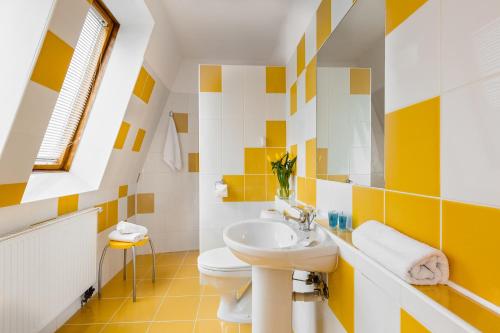 y baño blanco y amarillo con lavabo y aseo. en Villa Elefant, en Międzyzdroje