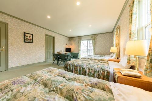 a hotel room with two beds and a desk at Ginga no Yado Kinoko2seigo in Shimo-tashiri