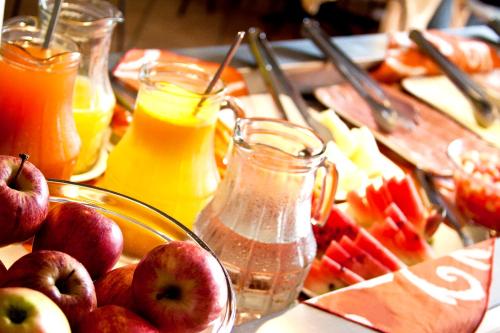 een tafel met appels en ander fruit en sap bij Hotel Tavares Correia in Garanhuns