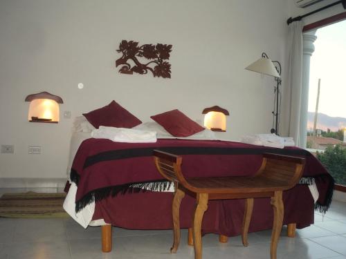 a bedroom with a bed with red and white sheets at Hotel Portal del Santo in Cafayate