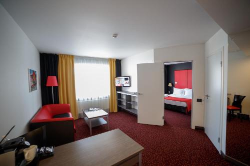 クルガンにあるAvenue Park Hotelのベッドとリビングルームが備わるホテルルームです。
