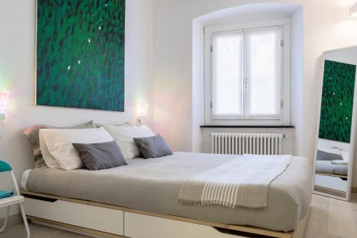 a white bedroom with a large bed and a window at Portofino Dream Flexyrent in Portofino