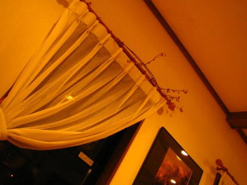 a window with a curtain in a room with a television at Anise Garden in Hakuba
