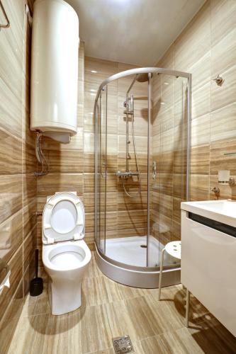 a bathroom with a shower and a toilet and a sink at Complex Hunter's Beach in Shkorpilovtsi