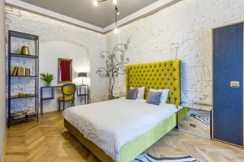una camera con un grande letto con testiera gialla di Köte Haus a Cluj-Napoca
