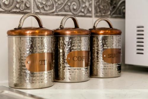 four metal canisters sitting on top of a counter at Cricket Field House in Salisbury