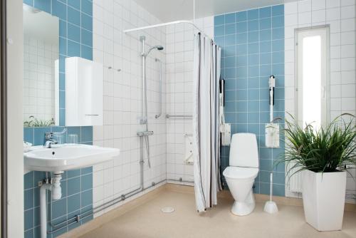a bathroom with a shower and a toilet and a sink at Attendo Park Hotell in Huddinge