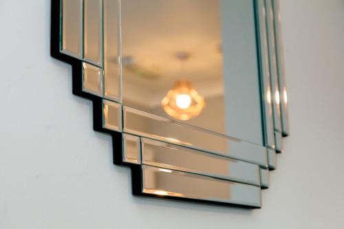 a mirror hanging on a wall with a light at Cricket Field House in Salisbury