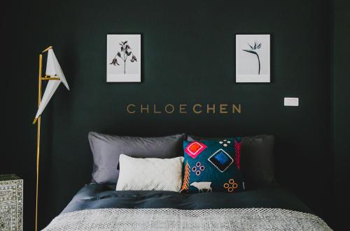 a bedroom with a dark green wall with a bed at Chloechen Home in Taitung City