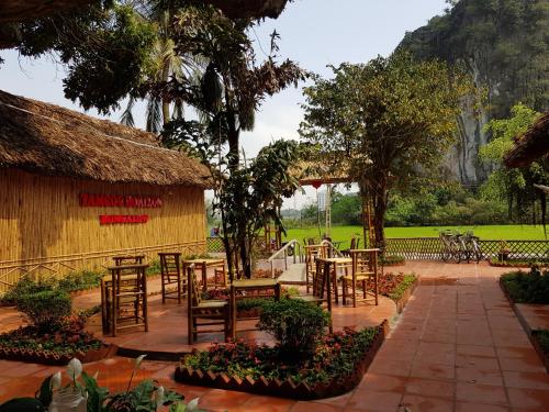 a patio with tables and chairs and a building at Tam Coc Horizon Bungalow in Ninh Binh