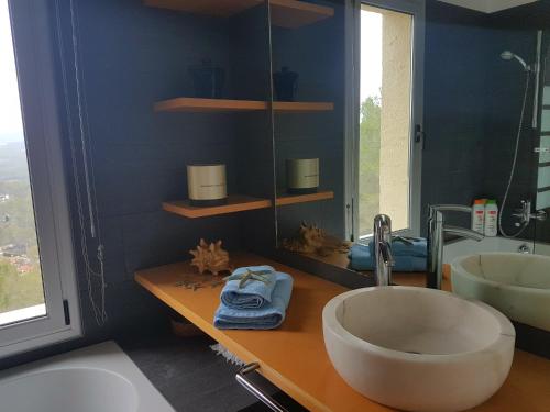 ein Badezimmer mit einem großen Aufsatzwaschbecken und einem Spiegel in der Unterkunft Villa Mur - Espectacular villa cerca de Sitges y BCN in Olivella